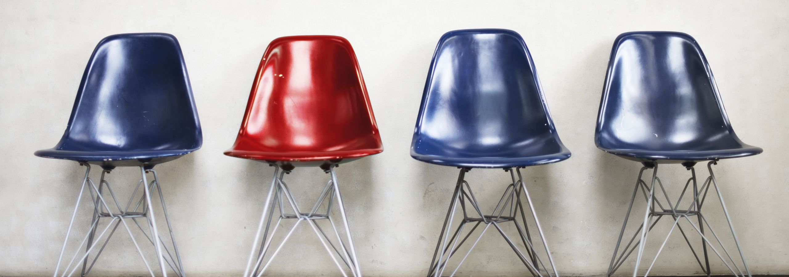 three blue chairs and one red chair in a row